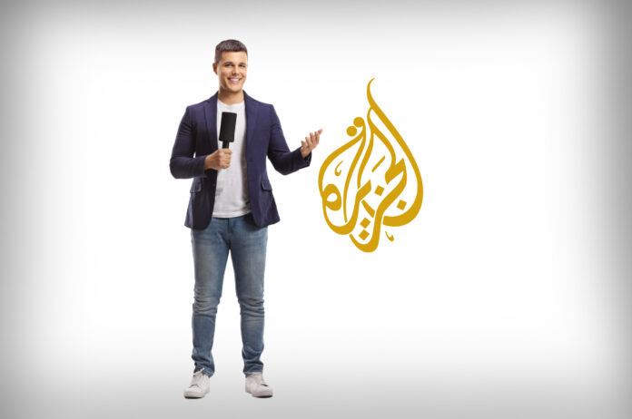 صورة لصحفي بجانب شعار قناة الجزيرة الإعلامية